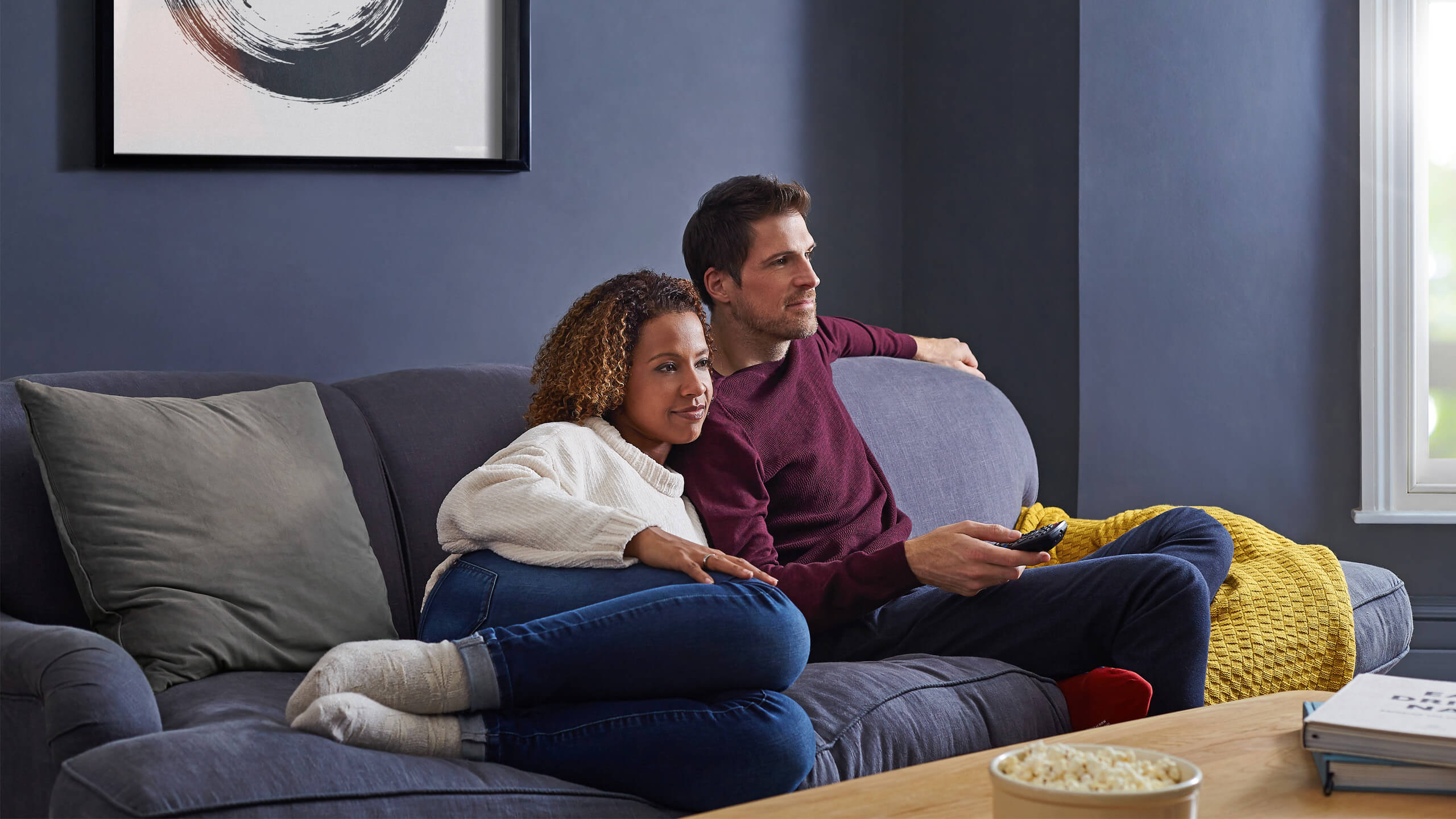 Couple watching TV while sitting on a sofa