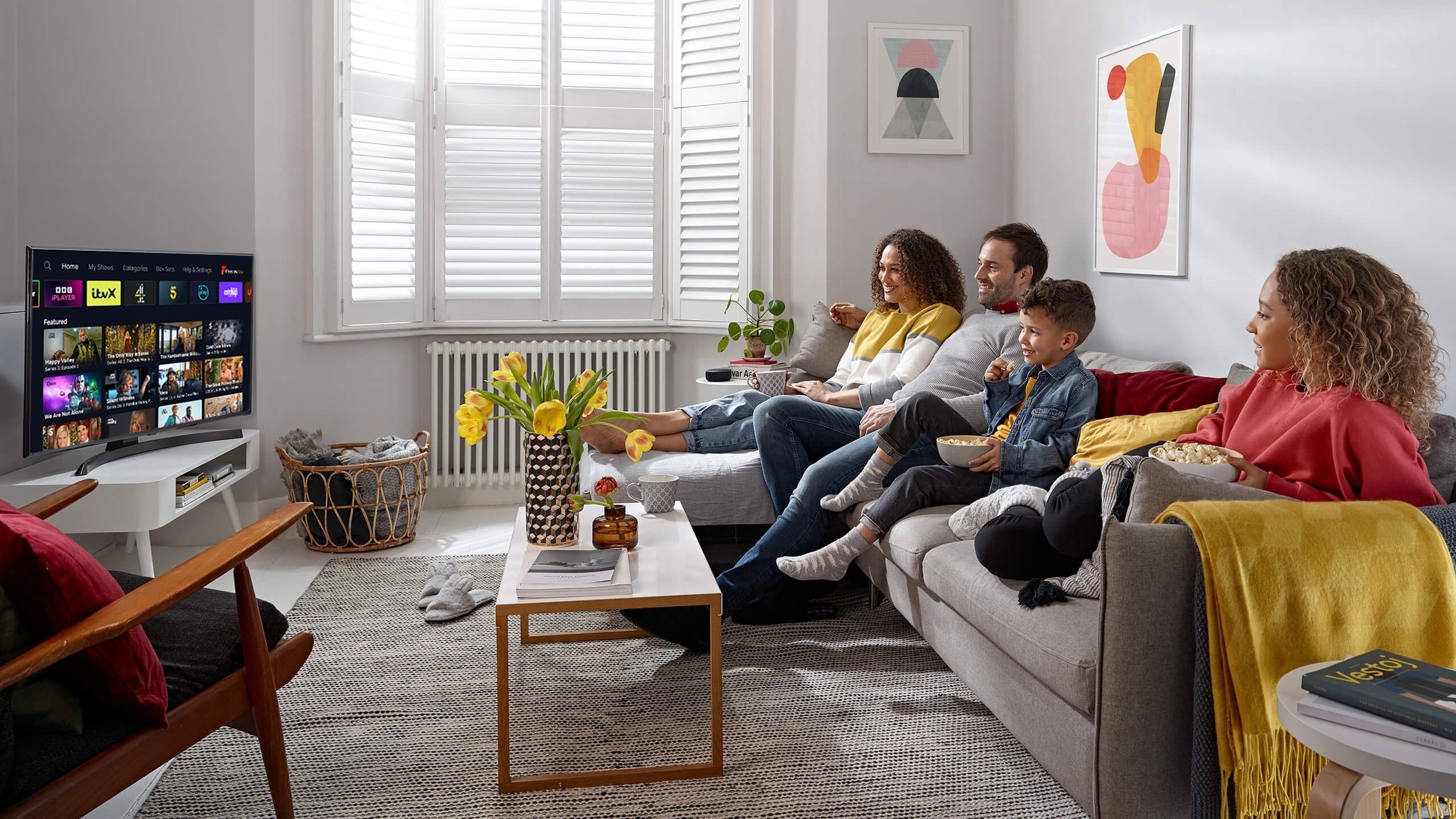 Family sitting on a sofa watching TV